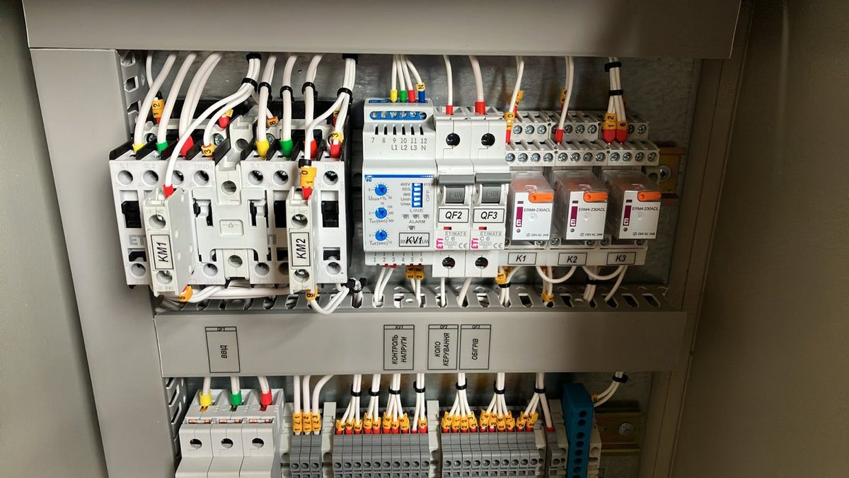 Реверсивна схема — контактори KM1 і KM2, реле контролю напруги, проміжні реле K1–K3